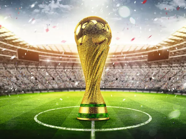 Imagem da Taça FIFA no centro de um gramado de um estádio de futebol lotado