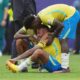Atletas com a camisa amarela da Seleção Brasileira consolam Neymar sentado no gramado chorando e cabisbaixo após o apito final na Copa de 2026.